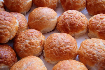 Baked sweet buns on a baking sheet with a ruddy crust, homemade delicious cakes