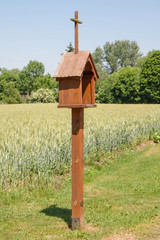 A small wooden shrine by a field