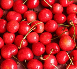Red ripe juicy sweet cherry lies on vintage wooden background. Sweet summer berries.