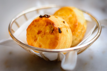 plain scone and raisin scone in basket with white linen