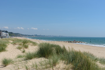 Fototapeta na wymiar Sandbanks beach with the dunes and Bournemouth in the distance