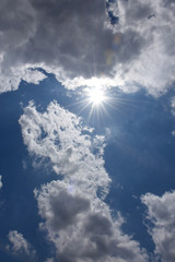 輝く太陽と青空と雲「空想・太陽の熱でとけはじめたモンスター（とけだしたドラゴンなどのイメージ）」熱い、暑い、熱中症、紫外線、日射病、紫外線遮断、ＵＶケア、とけるなどのイメージ