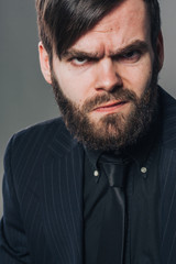 Obraz premium handsome unshaved man in black on grey wall