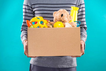 Male volunteer holding donation box with old toys.