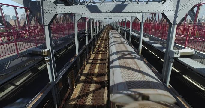 A unique perspective of looking down at a subway train as it passes directly underneath a pedestrian on the Williamsburg Bridge between Manhattan and Brooklyn. Part 2 of 2.  	