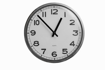 Black and white round wall clock shows almost one o'clock isolated on white background