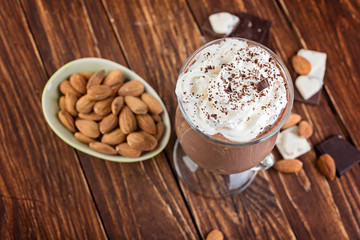 Homemade milkshake ( smoothie) with nuts and chocolate pieces on rustic wooden table