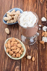 Homemade milkshake ( smoothie) with nuts and chocolate pieces on rustic wooden table