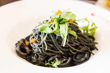 Close-up on simple squid ink pasta with squid and vegetable