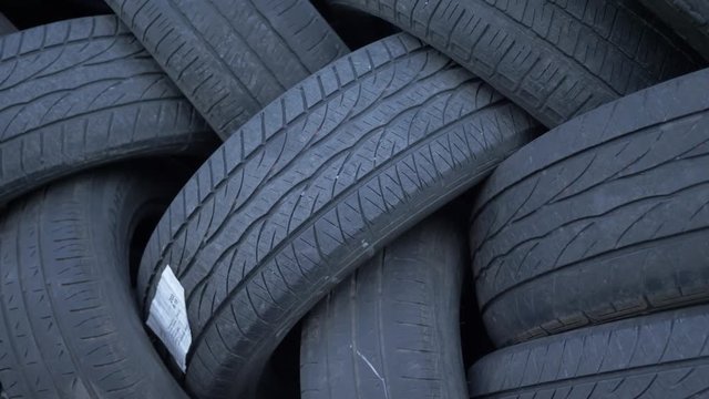 Closeup panning of a stack of car tires disposed