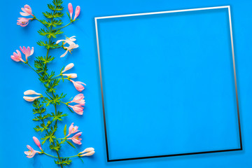 Abstract background empty frame of blue color with pink and white flowers and natural green leaves for greeting cards, certificate, congratulations
