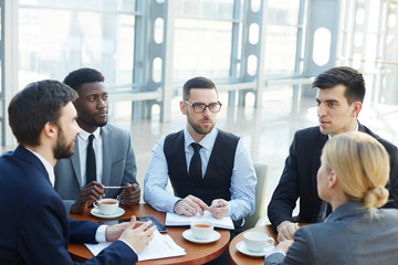 Group of modern business people meeting in office building discussing work