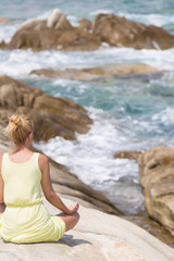 Woman meditating on the beach