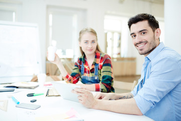 Obraz premium Two groupmates sitting by desk at lesson