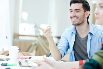 Young man attracting attention of groupmate to something