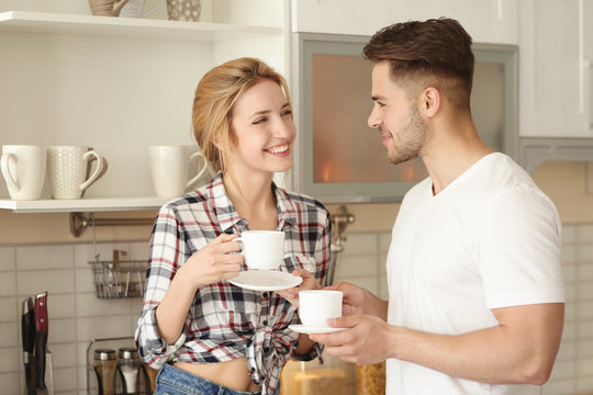 Morning of happy young couple drinking tea in kitchen