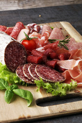 Food tray with delicious salami, pieces of sliced ham, sausage,