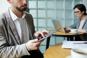 Closeup portrait of business people working at separate tables in co-working space, using portable computers