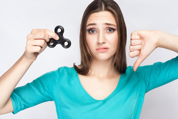 Young beautiful girl holding and playing with fidget spinner. studio shot on white background.