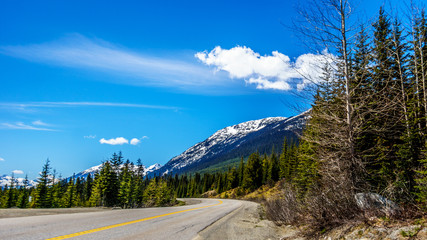 View of the snow capped Coast Mountains along Highway 99, also called The Duffey Lake Road, as it winds through the Coast Mountain Range between Pemberton and Lillooet in southern British Columbia