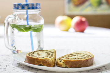 Strudel on the plate and jar with straw full of water with mint