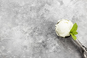 Mint ice cream in spoon on a gray background. Top view, copy space. Food background