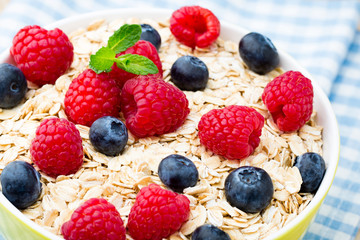 Oatmeal porridge with berries. Raspberries and blueberries.