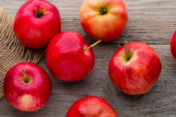 Ripe red apples on wooden background.