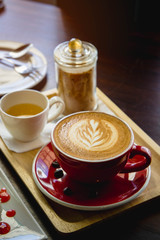 latte coffee red cup and cake on the wood table in the coffee shop cafe