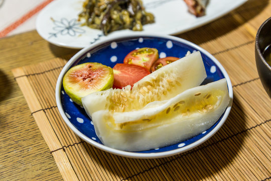 Fresh fruits after breakfast - honeydew melon, fig and tomato.
