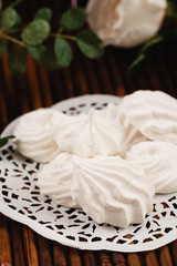 Fototapeta na wymiar White homemade zephyr or marshmallow on wooden background