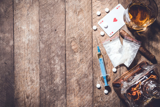 Overhead shot of hard drugs on an old wooden table.