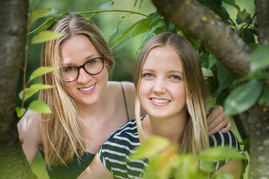 Zwei blonde M&auml;dchen im Portrait - 2 Frauengesichter zwischen den B&auml;umen 