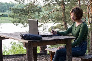 Fototapeta premium Beautiful young girl using her graphic tablet outdoors