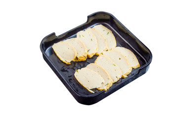 Fish cake or fried fish-line on black plate isolated on white. Clipping path. Shabu Shabu ingredient.