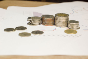 Stack money or coin on white paper graph. Conceptual growing or saving money for business and finance