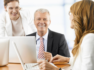 Obraz premium Financial business group. Shot of a senior financial manager and his business team working together on laptops in the office.