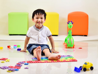 Asian boy playing toys in living room
