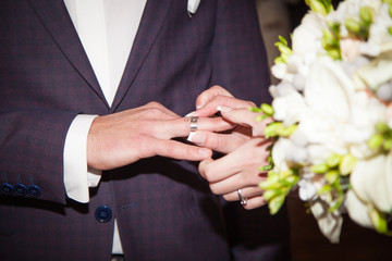 Obraz na płótnie Canvas Close up Groom Put the Wedding Ring on bride