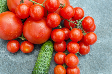 red tomatoes, cucumbers and dill on the board