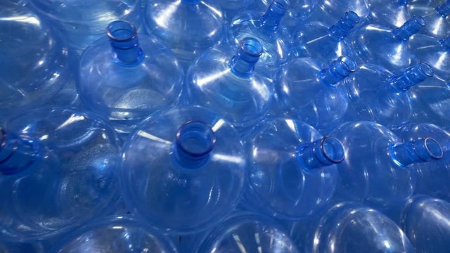 Numerous 19 liter plastic bottles for drinking water distribution.