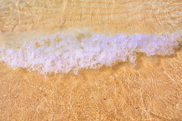 Soft wave with clear water ocean on sandy beach for Background with copy space