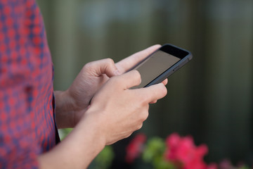 Man's hands using mobile smartphone outdoors