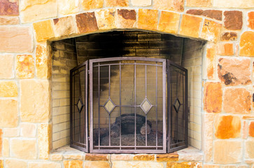 Limestone outdoor fireplace with mesh grate
