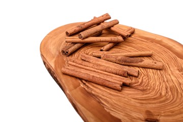 Cinnamon on wooden board isolated on white background