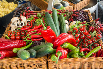 Fresh vegetables: tomatoes, cucumbers, lettuce, peppers, champignons in the basket at the street farm market, Frankfurt am Main, Germany.