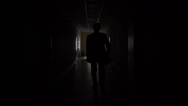 Slow motion. Silhouette of a man runs through the dark corridor. Dismissal.The Ghost of a businessman .The path to success.