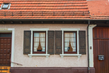 WALLDORF, GERMANY - JUNE 4, 2017: A close-up of german village residential house, its windows with old wooden shutters, wooden doors and tile roof.