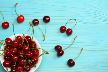 Fototapeta na wymiar Cherry on plate on blue wood background. top view with copy space
