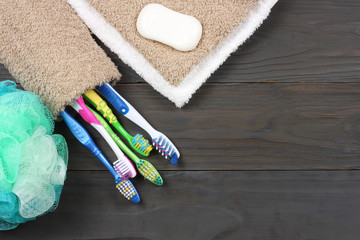 Obraz na płótnie Canvas toothbrush tooth-brush with soap, bath towel and wisp of bast on wood background top view with copy space